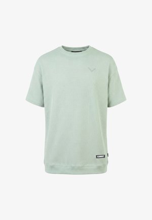 T-shirt vert clair à manches courtes en tissu gaufré, col rond, avec une petite étiquette "KLEINIGKEIT" près de l'ourlet sur le côté droit à l'avant.