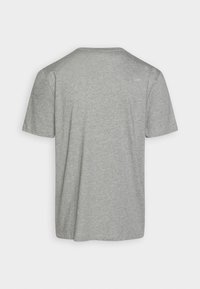 Camiseta gris de manga corta hecha de algodón suave; presenta un cuello redondo y un corte relajado con una textura lisa y sencilla.