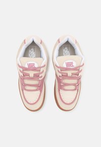 Para beżowo-różowych sneakersów Vans z białymi, wyściełanymi kołnierzami, różowymi sznurówkami i podeszwami z gumy, widzianych z góry na białym tle.