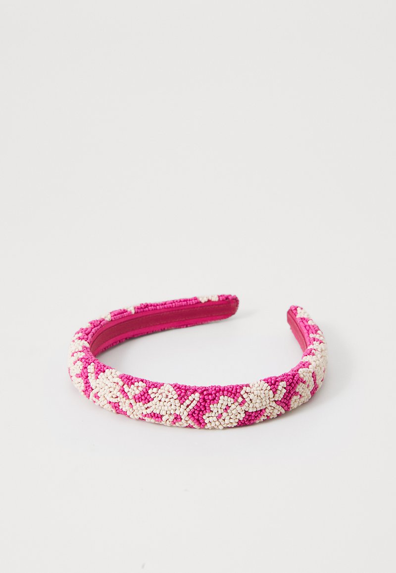 Beaded headband z roza osnovo in belim cvetličnim vzorcem. Gladka tekstura s ukrivljeno obliko in oblazinjenim notranjim delom za udobje.