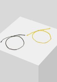 Due braccialetti intrecciati: uno di colore grigio scuro con piccoli perline argentate, l'altro di colore giallo brillante con perline abbinate, entrambi regolabili.