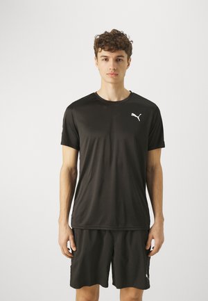 Czarna koszulka sportowa z gładkiego materiału syntetycznego, z okrągłym dekoltem i krótkimi rękawami. Logo Puma w białym kolorze na klatce piersiowej.
