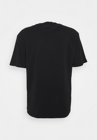 T-shirt nera a maniche corte, con scollatura rotonda e taglio dritto. Texture liscia con superficie uniforme e senza loghi visibili.