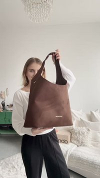 Brown fabric tote bag with wide straps and rounded edges. Features gold "Valentino" branding. Smooth texture, lightweight design.