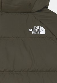 Giacca puffer verde oliva con texture trapuntata. Presenta un logo bianco "THE NORTH FACE" sull'area del petto sinistro.
