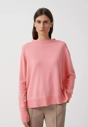 Rosa übergroßer Pullover mit hohem Kragen, langen Ärmeln und geripptem Saum. Weicher Stoff, lässige Passform und minimalistisches Design.