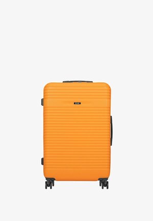Jasnopomarańczowa walizka z twardą skorupą z poziomymi rowkami, cztery czarne kółka i czarna rączka z boku.