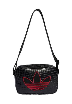 Bolso bandolera negro de imitación de cocodrilo con correa ajustable y gran logotipo de Adidas de trébol perfilado en rojo en la parte delantera.