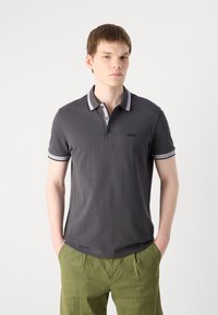 Pelēks polo krekls ar baltu striped apkakli un piedurkņu malām, ar funkcionālu poga plāksni un logotipa detaļu uz krūts.