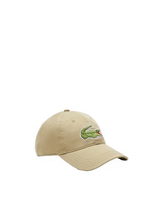 Gorra de algodón beige con un logo de cocodrilo bordado en verde en la parte frontal. Visera curva y correa ajustable en la parte trasera.
