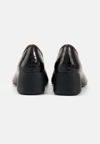 Pantofi cu toc din piele ecologică neagră, cu un aspect de crocodil, o suprafață texturată, un design unghiular și un toc solid.