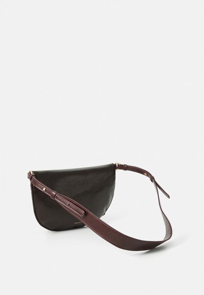 Sac à bandoulière en cuir noir avec une forme arrondie. Dispose d'une sangle bordeaux et de quincailleries en ton doré. Texture lisse avec un minimum de détails.
