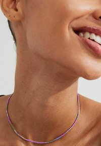Färgglad pärlhalsband med små glaspärlor i nyanser av rosa, lila och grått, med en slät yta och smal, rundad design.