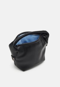 Czarna torebka z eko-skóry z zamknięciem na suwak, o zaokrąglonym kształcie i miękkiej fakturze; wnętrze wyłożone jasnoniebieską tkaniną. Posiada boczny akcent.