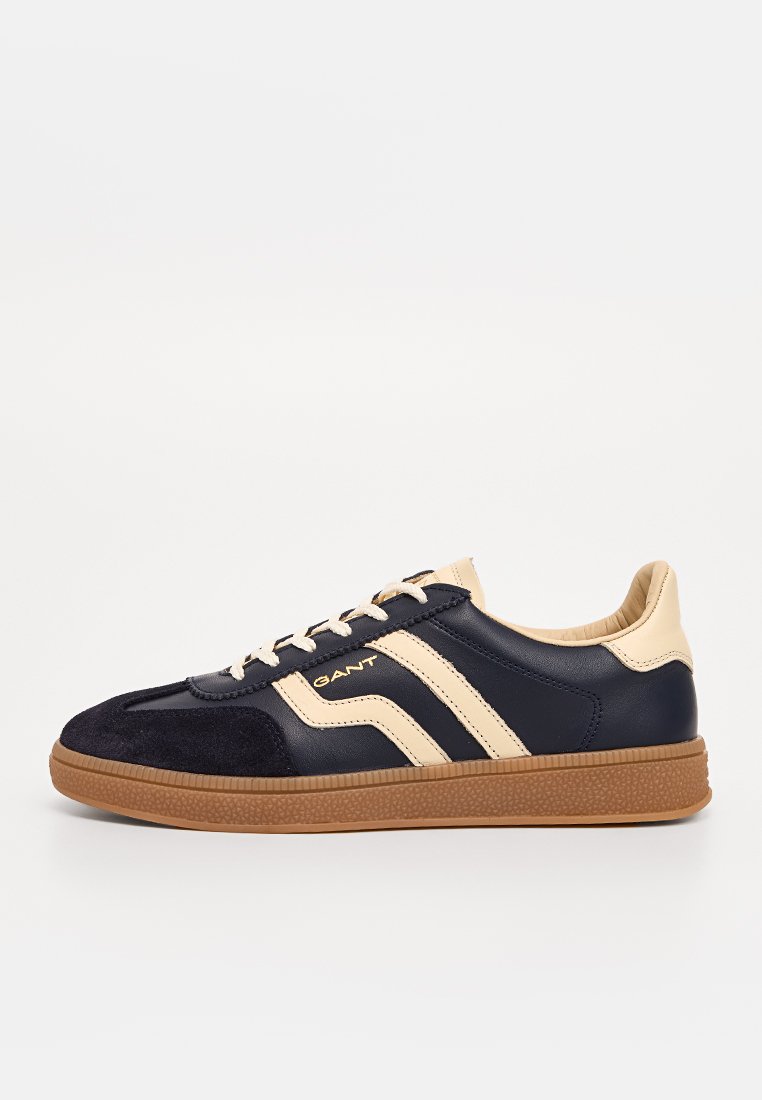 Navyblaue und beige Leder-Sneaker mit cremefarbenen Schnürsenkeln, Gummisohle, Wildleder-Zehenkappe und beigen Streifen mit "GANT"-Logo an der Seite.
