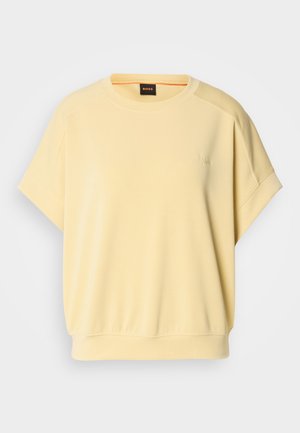 Sweatshirt amarelo de manga curta com decote redondo, corte descontraído e bainha canelada. Apresenta um discreto bordado do logótipo no peito. Textura de tecido suave.