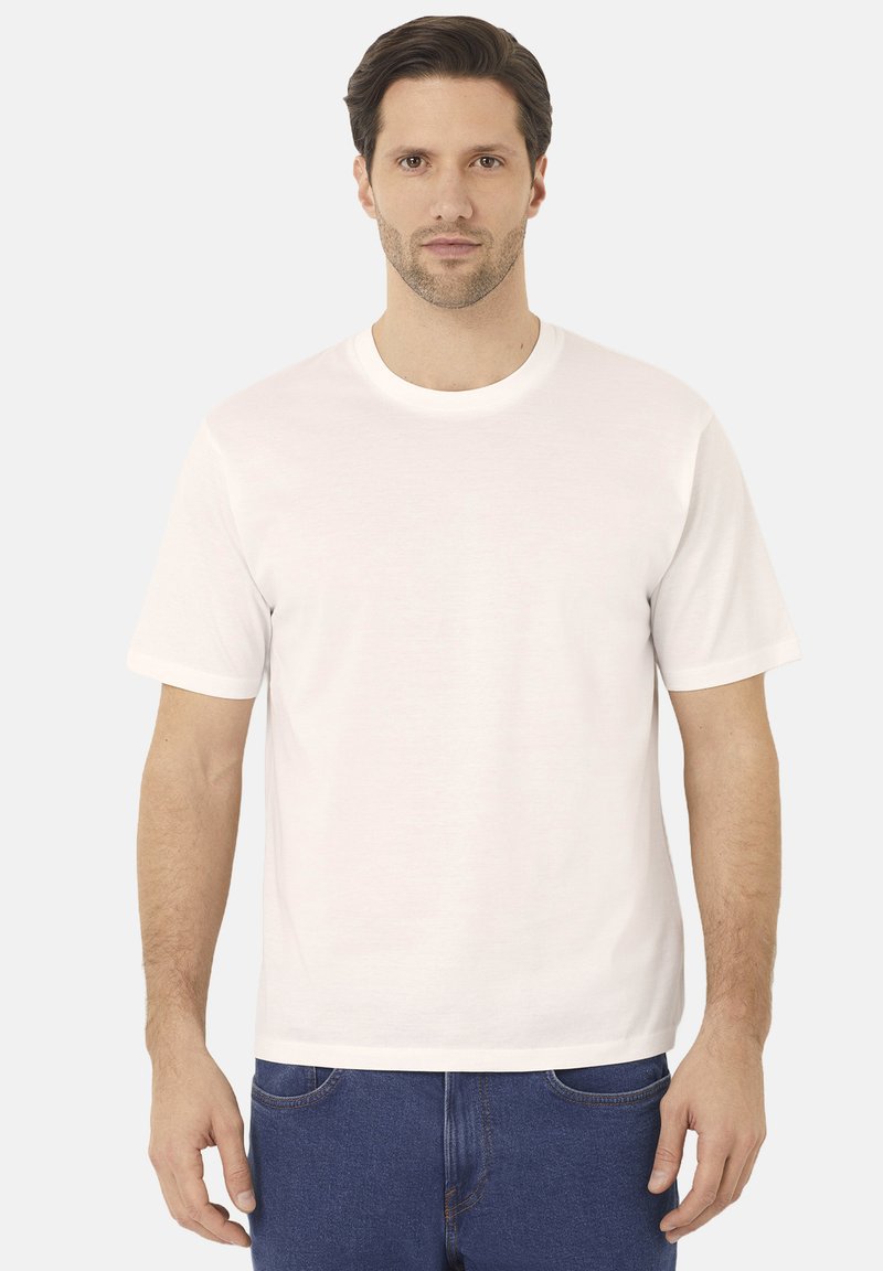 Bílá bavlněná tričko s krátkými rukávy, kulatým výstřihem a volným střihem. Tkanina vypadá hladce a lehce, bez vzorů.