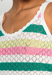 Dzianinowy top bez rękawów z falistym dekoltem, w poziome paski w zielonym, różowym, żółtym i białym kolorze, z wzorem koronkowym.