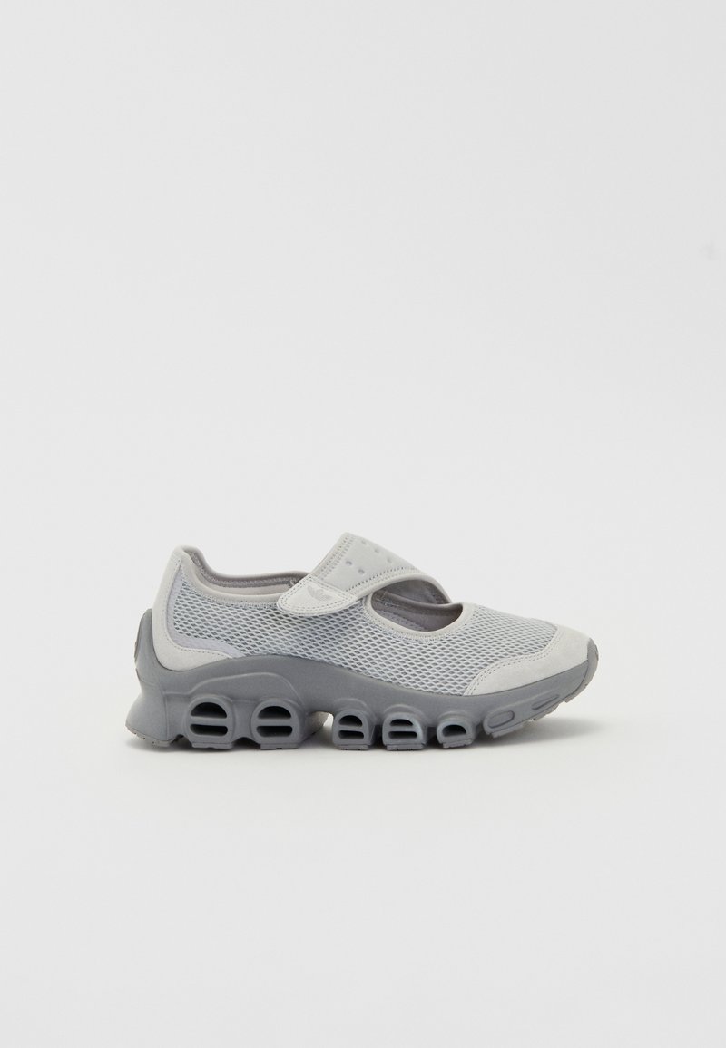 Graue Sportschuhe aus Netz- und Synthetikmaterial. Mit einem Klettverschluss, runder Zehenpartie und einer dicken, strukturierten Sohle mit Ausschnitten.
