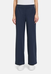 Pantaloni a gamba larga blu navy realizzati in morbido tessuto con vita elasticizzata, dotati di una tasca frontale e una superficie liscia.