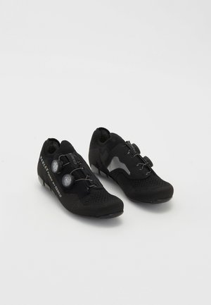 Black cycling shoes with a breathable mesh upper, sleek design, two dial closures, and textured surfaces. Features a reinforced toe and heel.