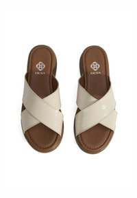 Beige kruisbanden slipper sandalen gemaakt van glanzend materiaal met een krokodillenpatroon. Bruin gevoerd voetbed. Lichtgewicht zool. Merkl logo zichtbaar.