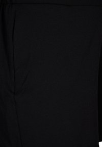Primo piano di tessuto nero, texture liscia, leggermente elasticizzato, con drappeggio sottile e una leggera lucentezza, caratterizzato da un design pulito e minimalista.