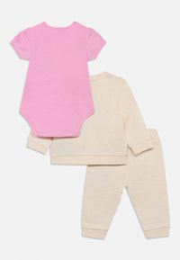 Σετ βρεφικών ρούχων που περιλαμβάνει ένα ροζ κορμάκι με κοντά μανίκια και ένα κρεμ πουλόβερ με παντελόνι που ταιριάζει, μαλακό ύφασμα και εφαρμοστά τελειώματα στα μανίκια.