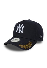 Kék baseballsapka fehér hímzett logóval. Állítható pánttal rendelkezik, és bonyolult arany virágminták díszítik a karimáját.
