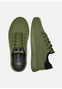 Olivgrüne Mesh-Sneaker mit strukturierter Oberfläche, abgerundeter Spitze und weicher, gepolsterter Sohle. Schwarze Akzente an der Ferse und am Logo auf der Zunge.