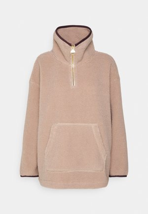Beiger Fleece-Pullover mit hohem Kragen, halbem Reißverschluss vorne, Kängurutasche und dunkler Einfassung an Kragen und Ärmelbündchen.