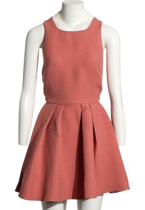 Robe rose corail sans manches avec corsage ajusté et jupe évasée plissée, présentée sur un mannequin blanc sur fond blanc.