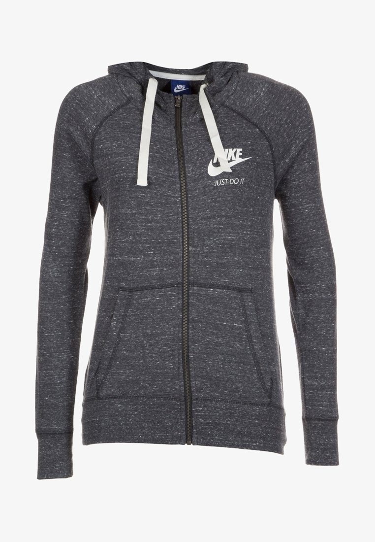 Tummanharmaa Nike-toppatakki, jossa on vetoketju, valkoiset kiristysnauhat, etutaskut sekä Nike-logo ja "Just Do It" -iskulause rinnassa.