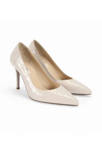 Escarpins en cuir verni beige à talons hauts avec un bout pointu, présentant une texture crocodile et un talon fin. Semelles intérieures plates avec un rembourrage doux.