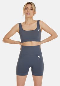 Top cropped sportivo grigio con scollatura quadrata e pantaloni corta a vita alta coordinati, realizzati in materiale a coste, con un accento del logo bianco.