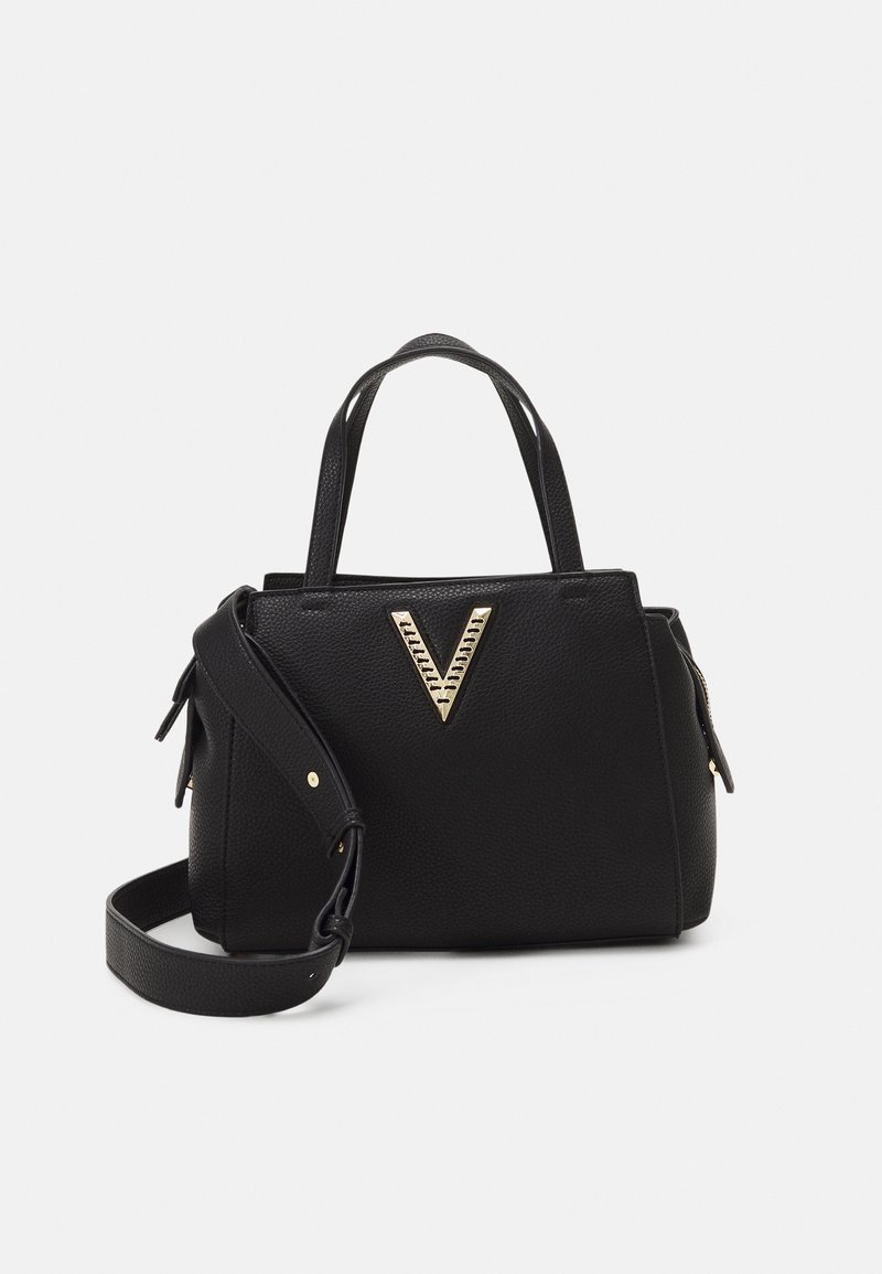 Svart texturerad handväska med två ovandelshandtag och en avtagbar axelrem, med en guldfärgad V-formad metalllogotyp på framsidan.