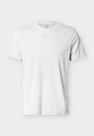 Weißes Reebok Sport-T-Shirt mit kurzen Ärmeln, kleinem rot-weißem Logo auf der Brust und dezenten hellgrünen Seitenakzenten.