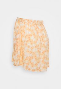 Květinová sukně s pozadím žluto-oranžové barvy, zdobená bílými a oranžovými vzory květin. Elastický pás; měkká, lehká tkanina.