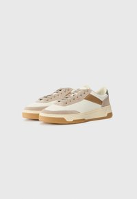 Adidași bej și crem cu un design texturat, accente din suede și o talpă din cauciuc. Prezintă o dâră triunghiulară de culoare maronie și șireturi asortate.
