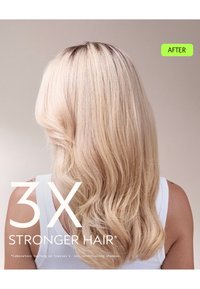 Långt, vågigt blont hår med en mjuk textur, sedd bakifrån. Håret ser glänsande och friskt ut, lager med en subtil mörkare rot.