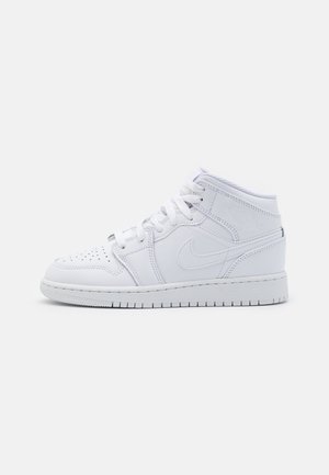 Baskets Nike Air Jordan montantes blanches avec embout perforé, lacets et logo Nike swoosh sur le côté, sur fond uni.