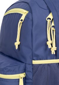 Zaino blu navy con zip gialle, coulisse intrecciate e dettagli in rete. Presenta più scomparti per l'organizzazione.