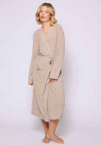 Beige kamerjas met lange mouwen, wikkelontwerp en witte accenten. Heeft twee voorzakken en een strikceintuur in de taille. Zachte textuur.