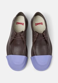 Brown leather shoes with a light purple rubber toe cap, featuring laces and a speckled insole labeled "CAMPER."