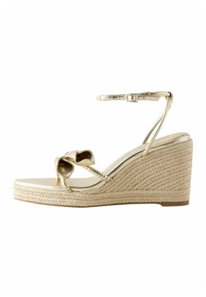 Goldene Keilsandale mit Knöchelriemen, vorderer Schleife und geflochtenem Seil-Plateauabsatz.