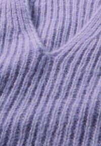 Lavendelfarbener Strickstoff mit vertikalen Rippen. Weicher, flauschiger Textur mit subtiler Glanz. Leichtes und flexibles Material.