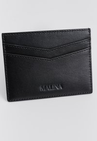 Μαύρο δερμάτινο θήκη καρτών με δύο λοξές θήκες. Διαθέτει ανάγλυφο λογότυπο "MALINA" και αντίθετη ραφή κατά μήκος των ακμών. Ομαλή υφή.