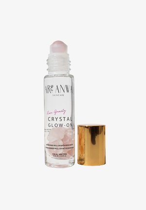 Clear glass roll-on bottle containing pink rose quartz crystals and rose water, topped with a shiny gold cap. Label features black text.