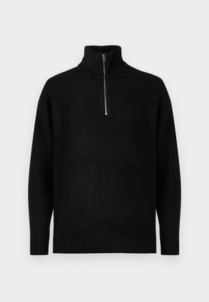 Juodas megztinis su aukštu apykakle, su pusiau užtrauktuku. Raštuoti rankogaliai ir apačia, lygus paviršius, minimalizmo dizainas.