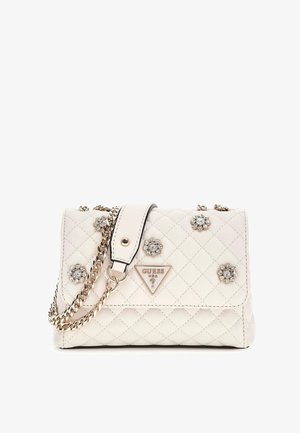 Quilted cream handbag with silver chain strap, embellished with flower-like rhinestones and a triangular Guess logo on the front.